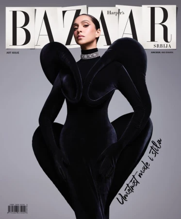 Magazine cover featuring a woman in a sculptural black dress with dramatic sleeves against a gray background, Harper's Bazaar Serbia.