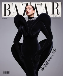 Model Britt Oosten wearing a sculptural black velvet avant-garde gown with exaggerated shoulders against a neutral grey studio background