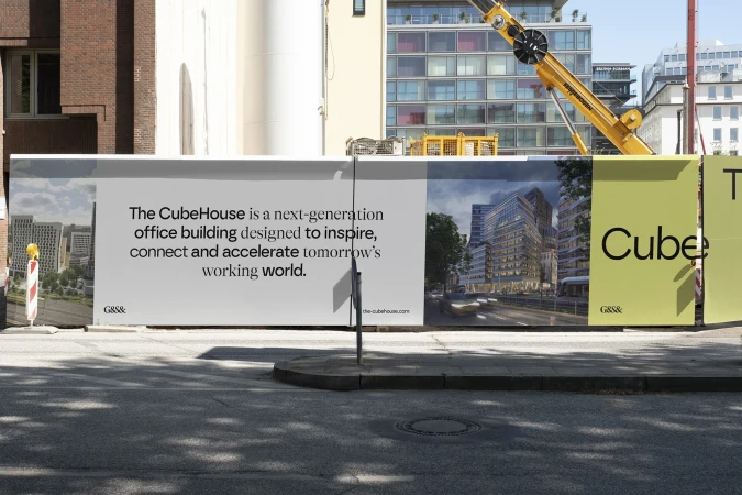 Billboard for The CubeHouse, a modern office building, featuring architectural renderings and text, set against an urban cityscape.