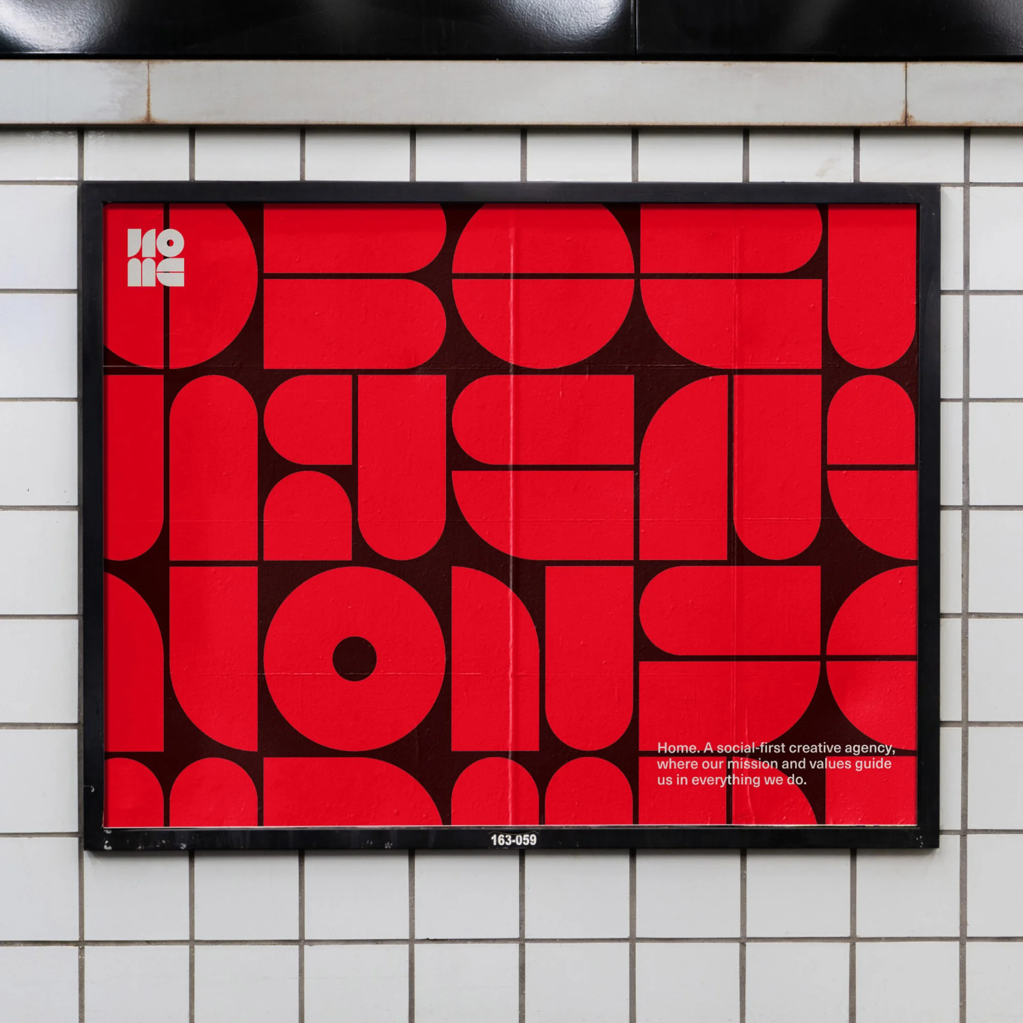 Red and black geometric poster in a black frame mounted on a white tiled wall in an indoor setting with visible text.