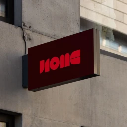 Red illuminated brand sign reading Home mounted on a raw concrete exterior wall