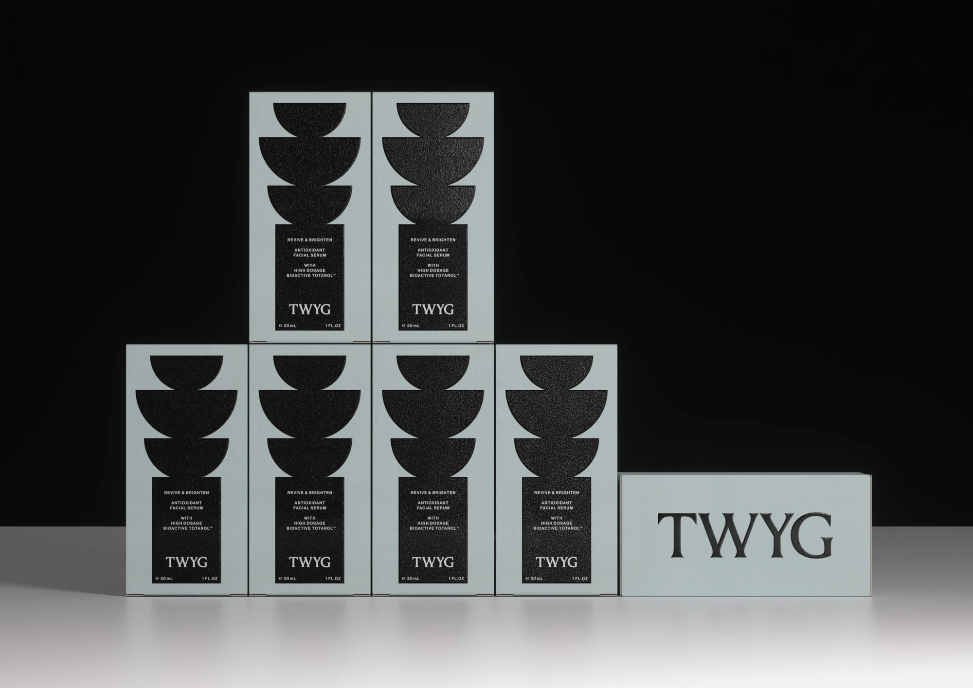 Several boxes of TWYG Revive & Brighten Antioxidant Facial Serum are displayed against a black backdrop in a studio setting.