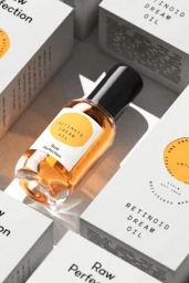Retinoid Dream Oil bottle surrounded by matching white packaging boxes by Raw Perfection