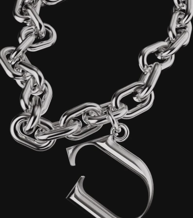 Silver chain necklace with an initial pendant against a dark background, studio shot for fashion or jewelry advertising.