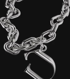 Close-up of a glossy metallic silver chain necklace featuring a hanging letter pendant against a solid dark grey background.