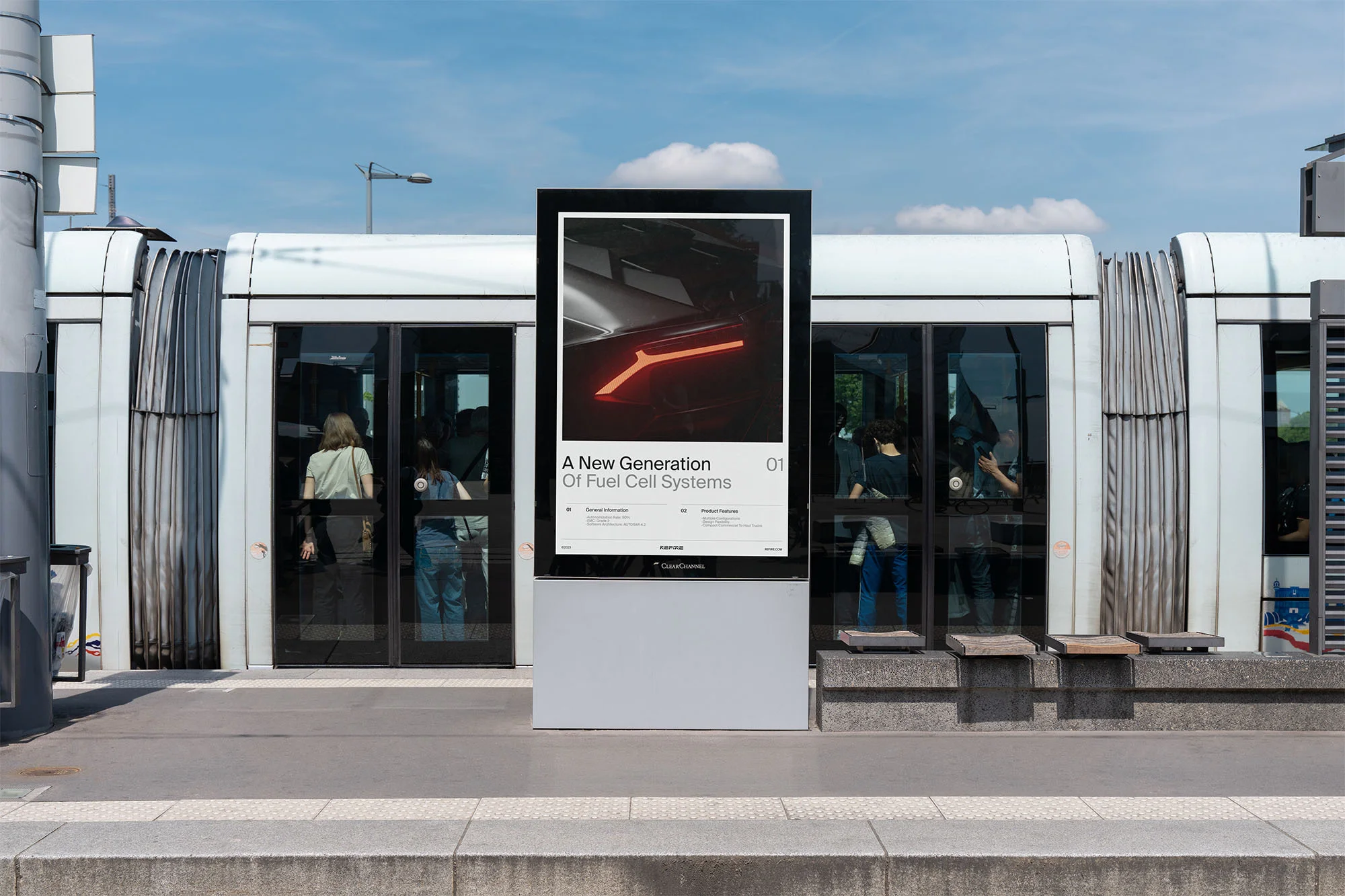 Outdoor advertising poster on a bus platform featuring a futuristic car design, with blurred people and a bus in the backdrop.
