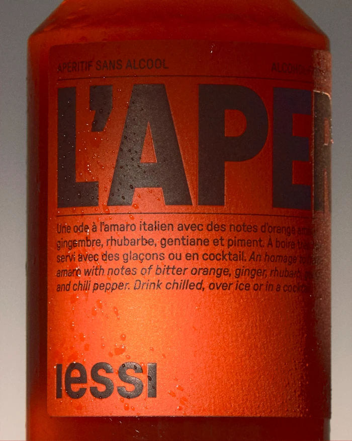 Close-up of a chilled orange beverage bottle with a red label for iessi brand identity