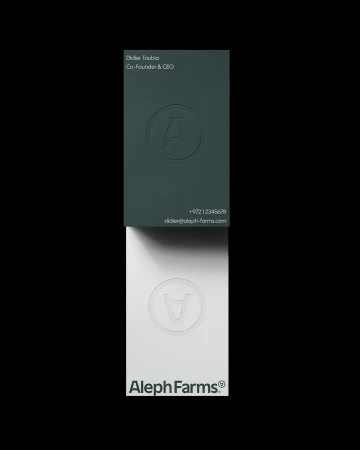 Elevated studio shot of two business cards in a vertical stack, one green with embossed logo and one white with printed logo.