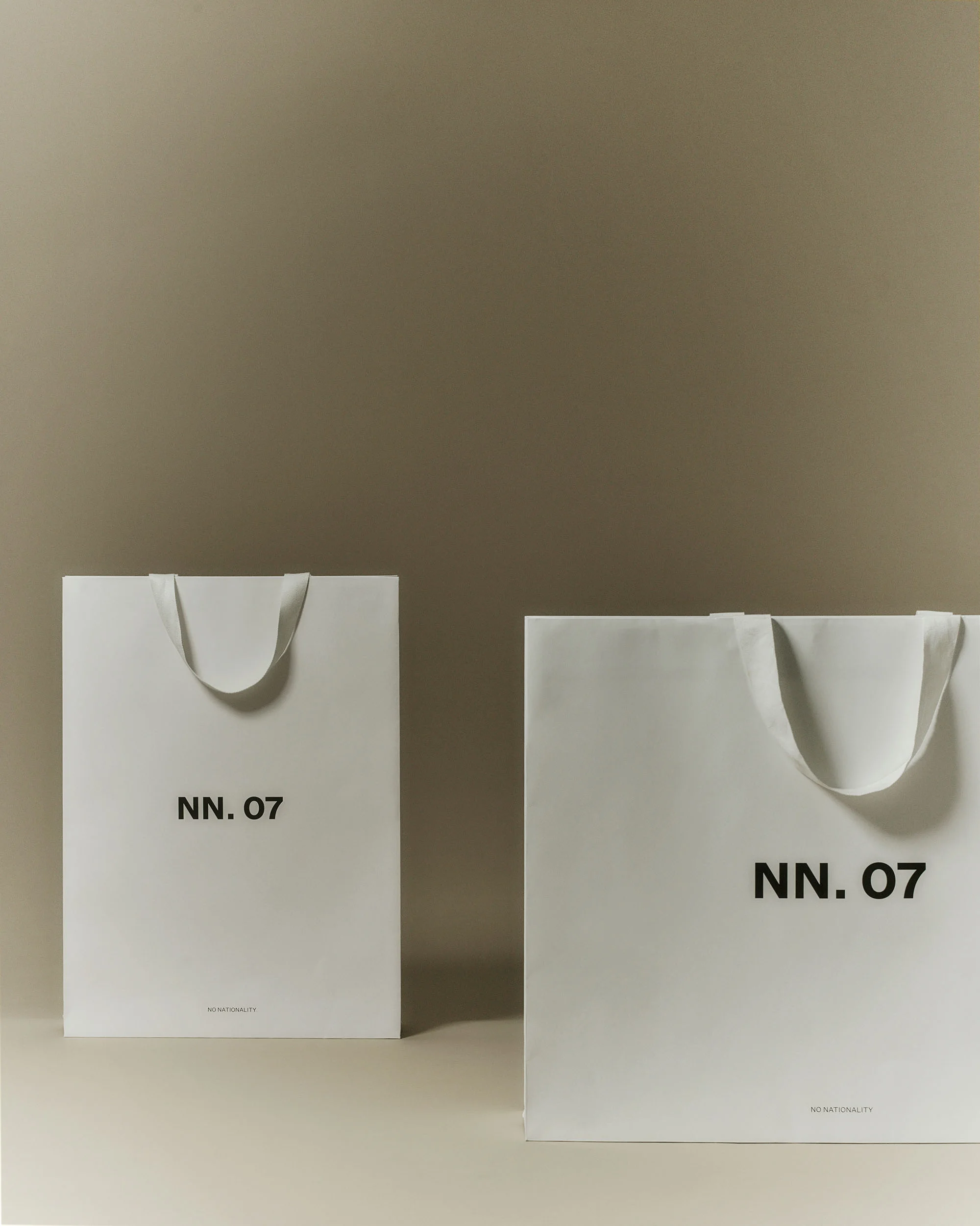 Two white shopping bags with the brand name NN. 07 on a neutral background, suggesting a fashion or retail context.