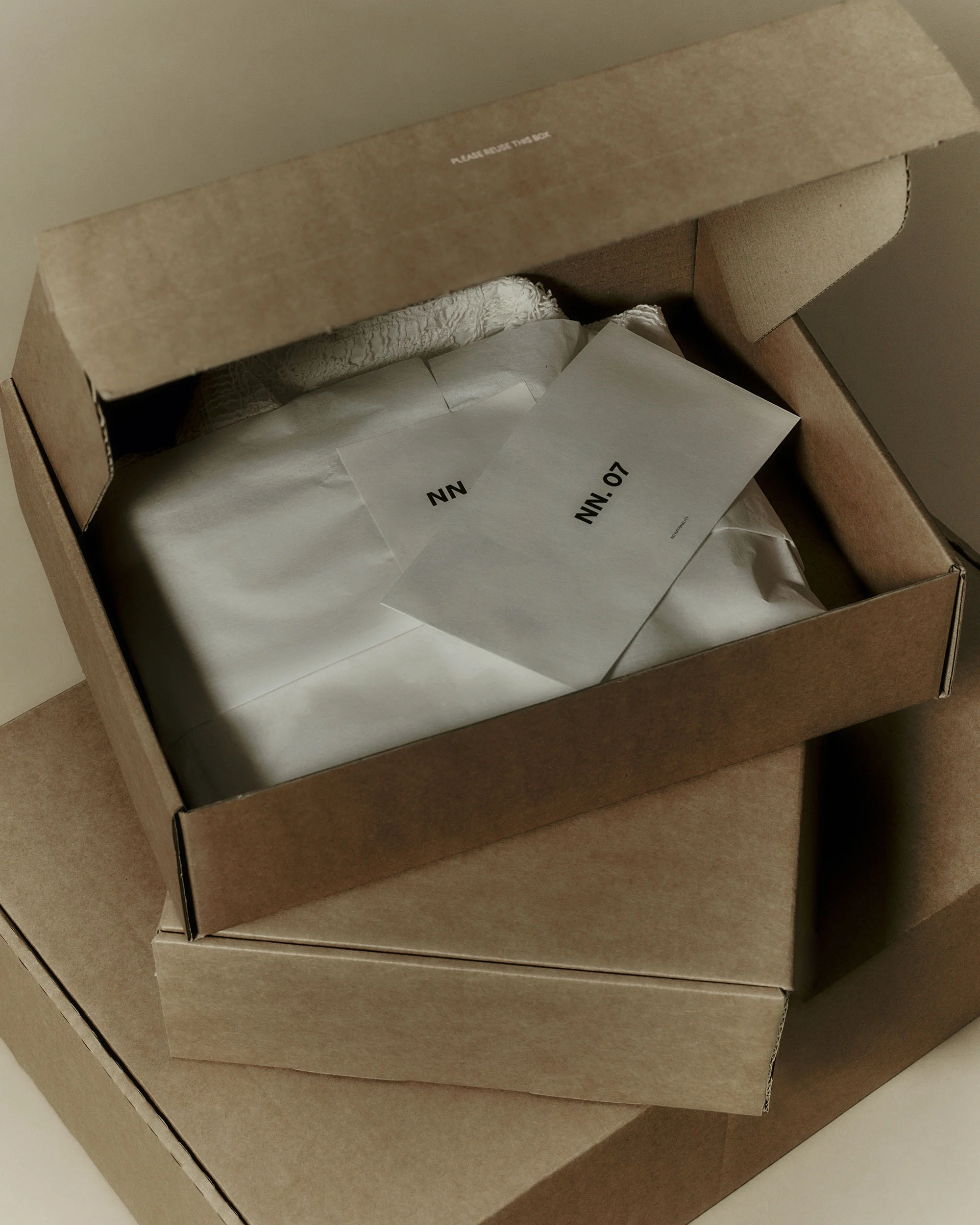 Unopened cardboard boxes with clothing and product information labels inside, conveying a sense of anticipation and unboxing experience.