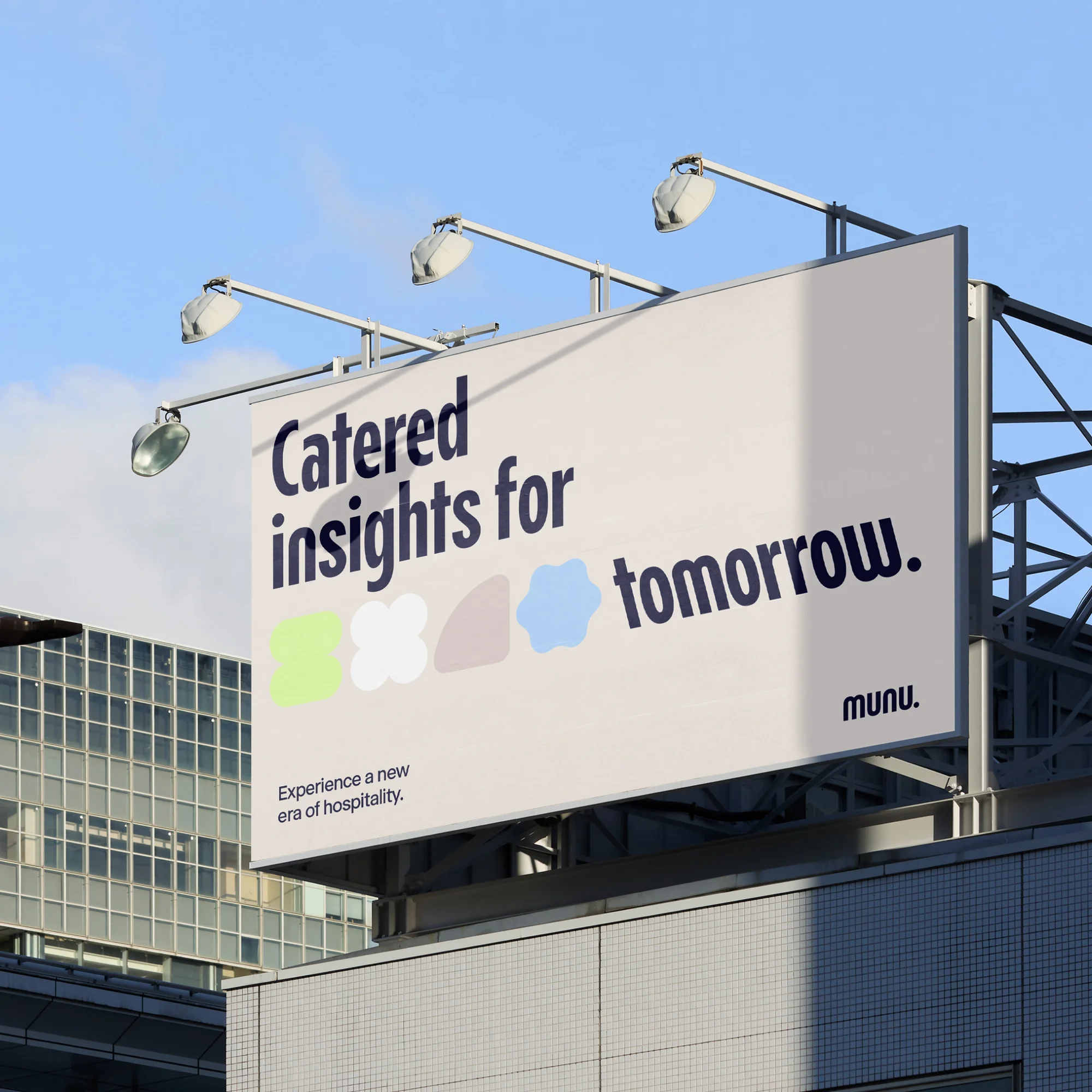Billboard featuring 'Catered insights for tomorrow' message with abstract shapes against a blue sky and a corner of a building.