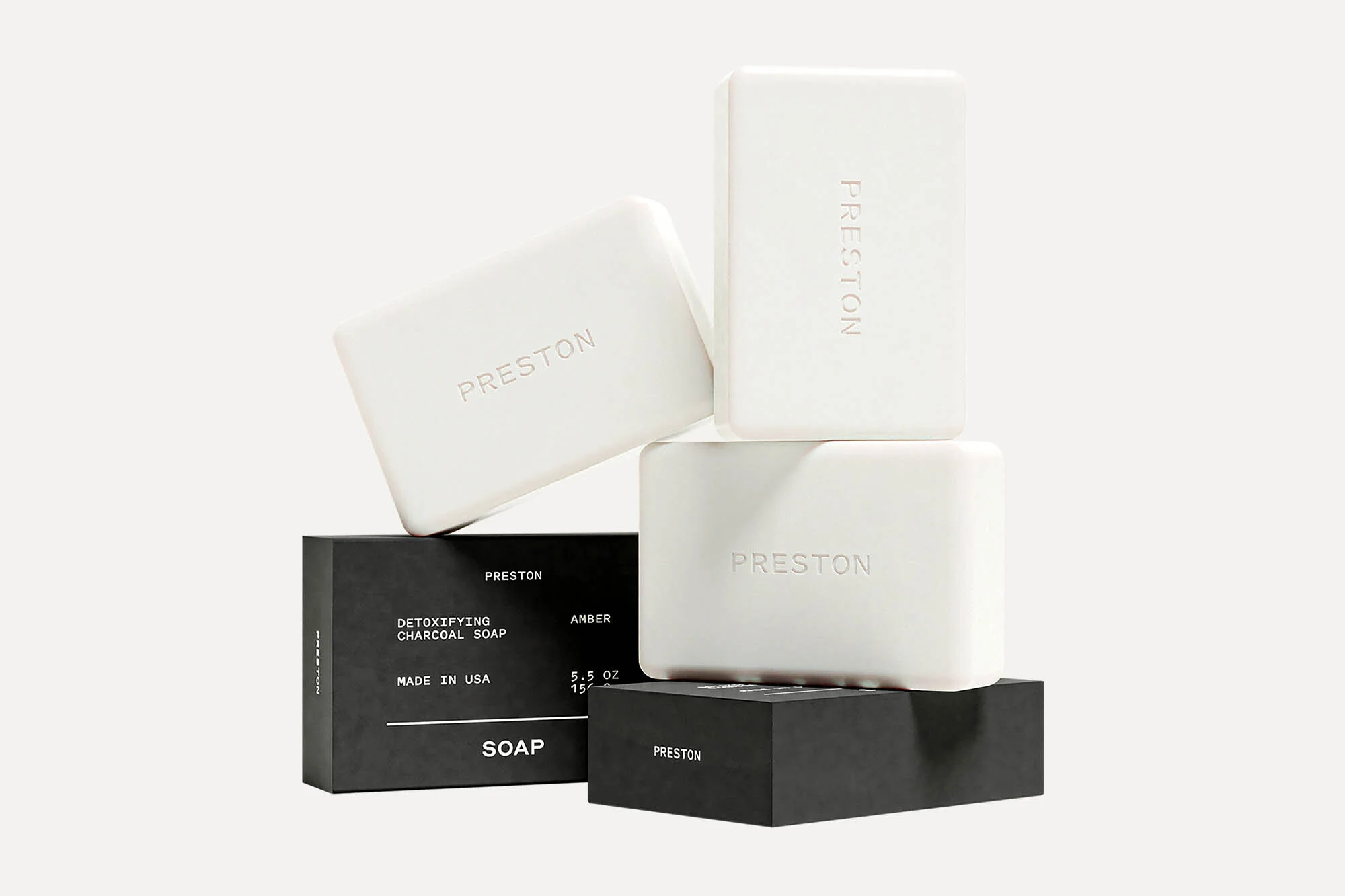Stacked arrangement of Preston brand soap bars and packaging in a minimalist product shot against a clean, neutral background.