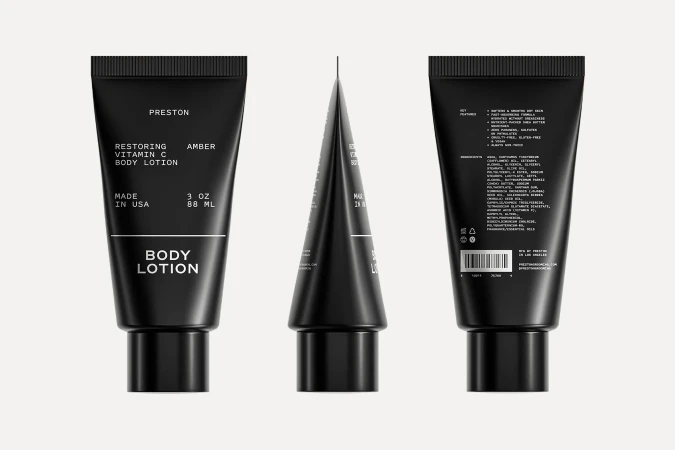 Three black tubes of Preston Restoring Vitamin C Body Lotion. The product label is white font. The background is a neutral off-white.