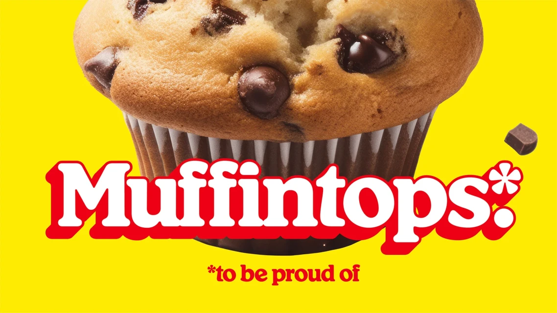 A close-up of a chocolate chip muffin against a bright yellow background with the brand name Muffintops in large red and white text.