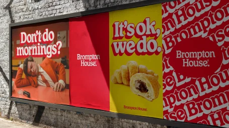 Billboards displaying Brompton House brand identity with graphic typography, croissant imagery, and a sleeping man in an orange suit.
