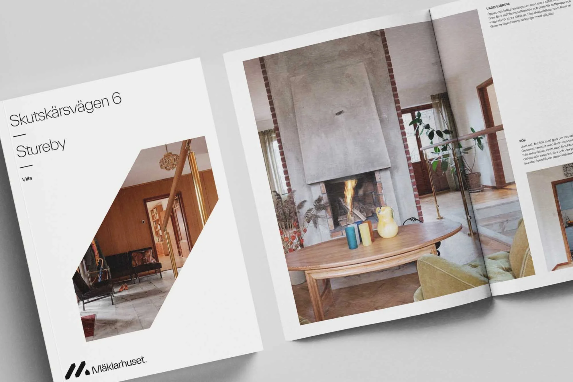 Open magazine featuring interior photography of a living room with a fireplace, wooden table, and minimal decor, showcasing home design.