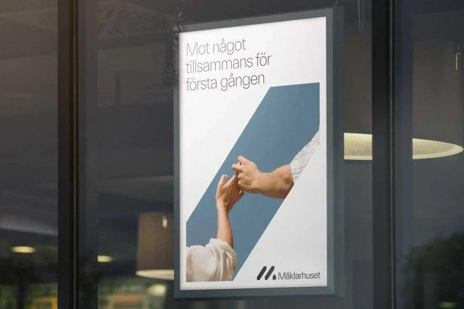 Real estate advertisement features two people interlocking fingers, shot through reflective glass, bathed in daylight, promoting Mäklarhuset.