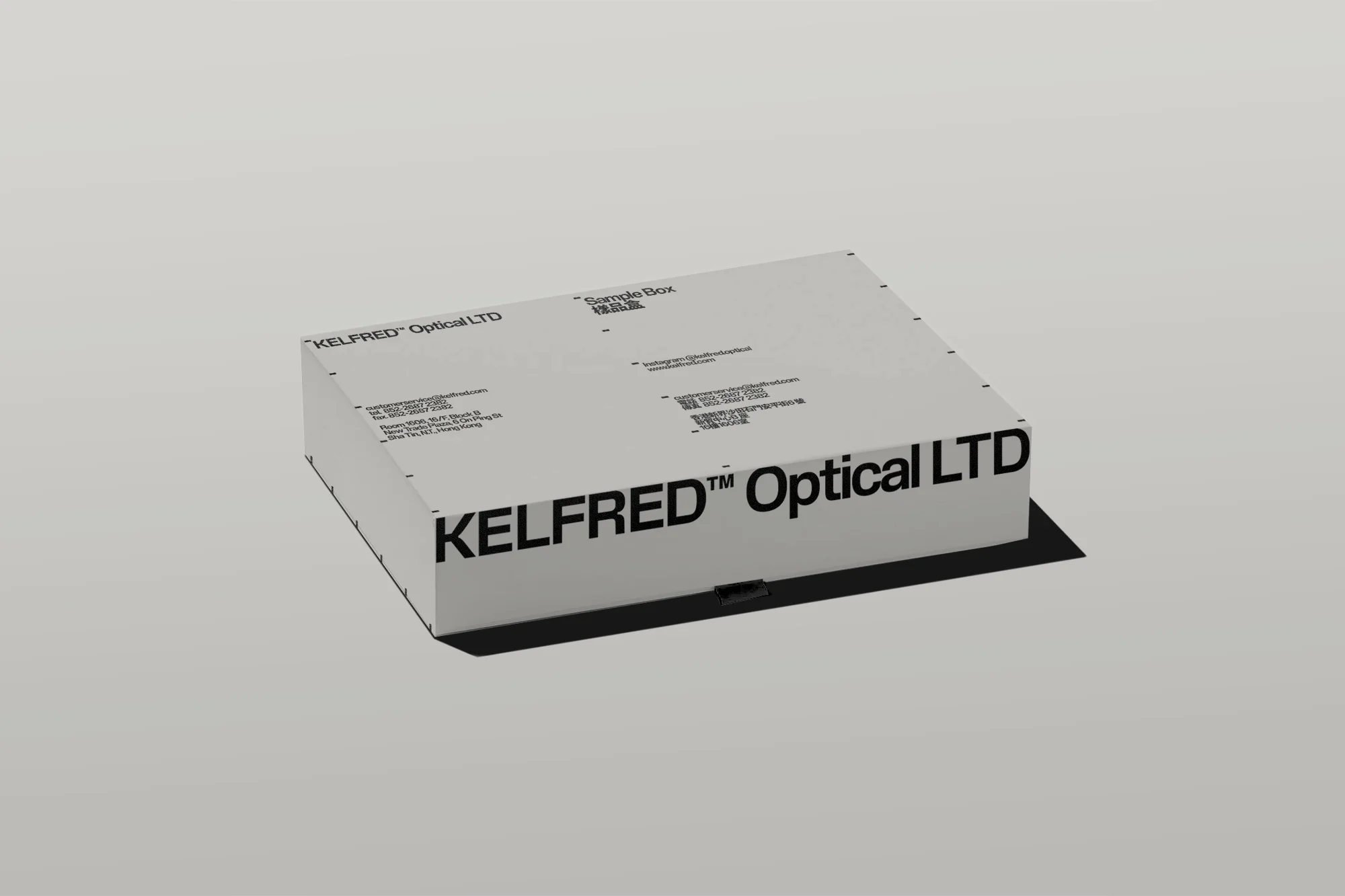 Product shot of a Kelfred Optical LTD sample box, displaying the company name and contact information against a gray background.