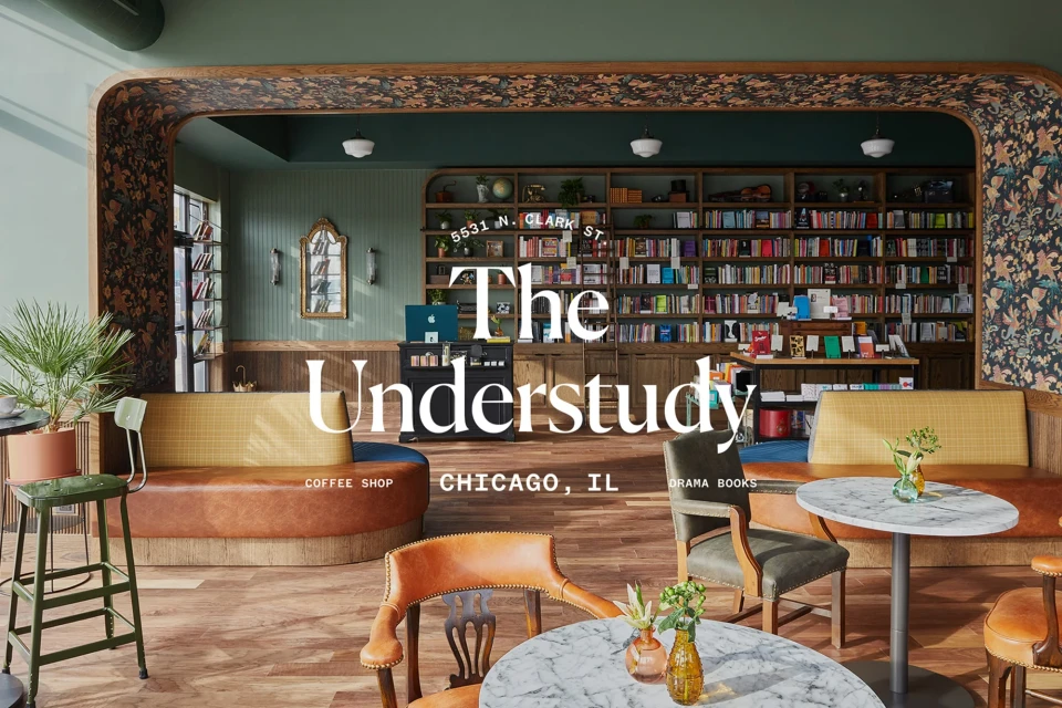 Interior view of The Understudy coffee shop in Chicago, Illinois featuring tables and chairs, bookshelves, seating, and plants.