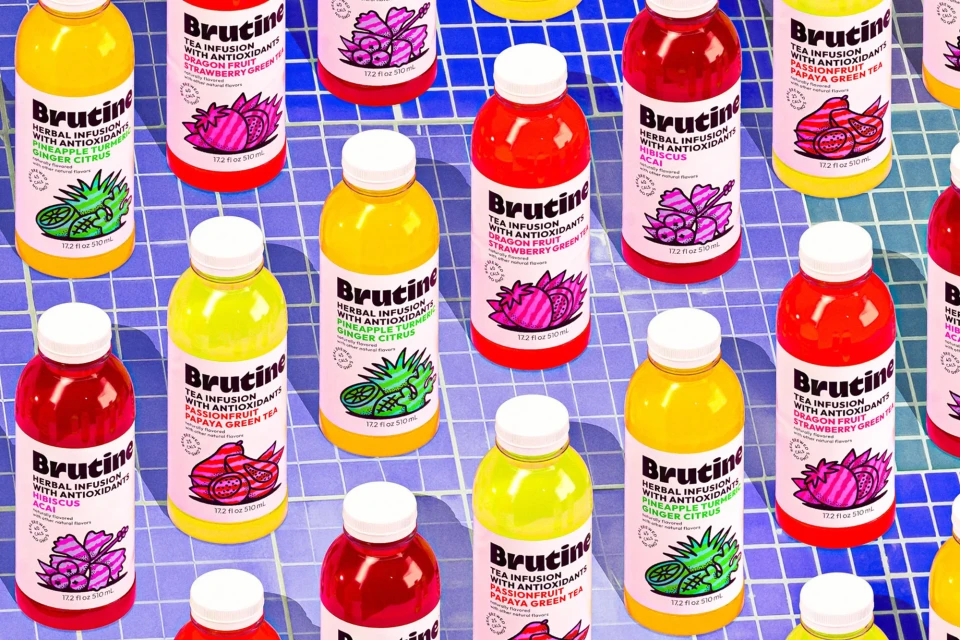 Colorful arrangement of Brutine herbal tea infusion bottles with various fruit flavors on a blue tiled surface, overhead shot.