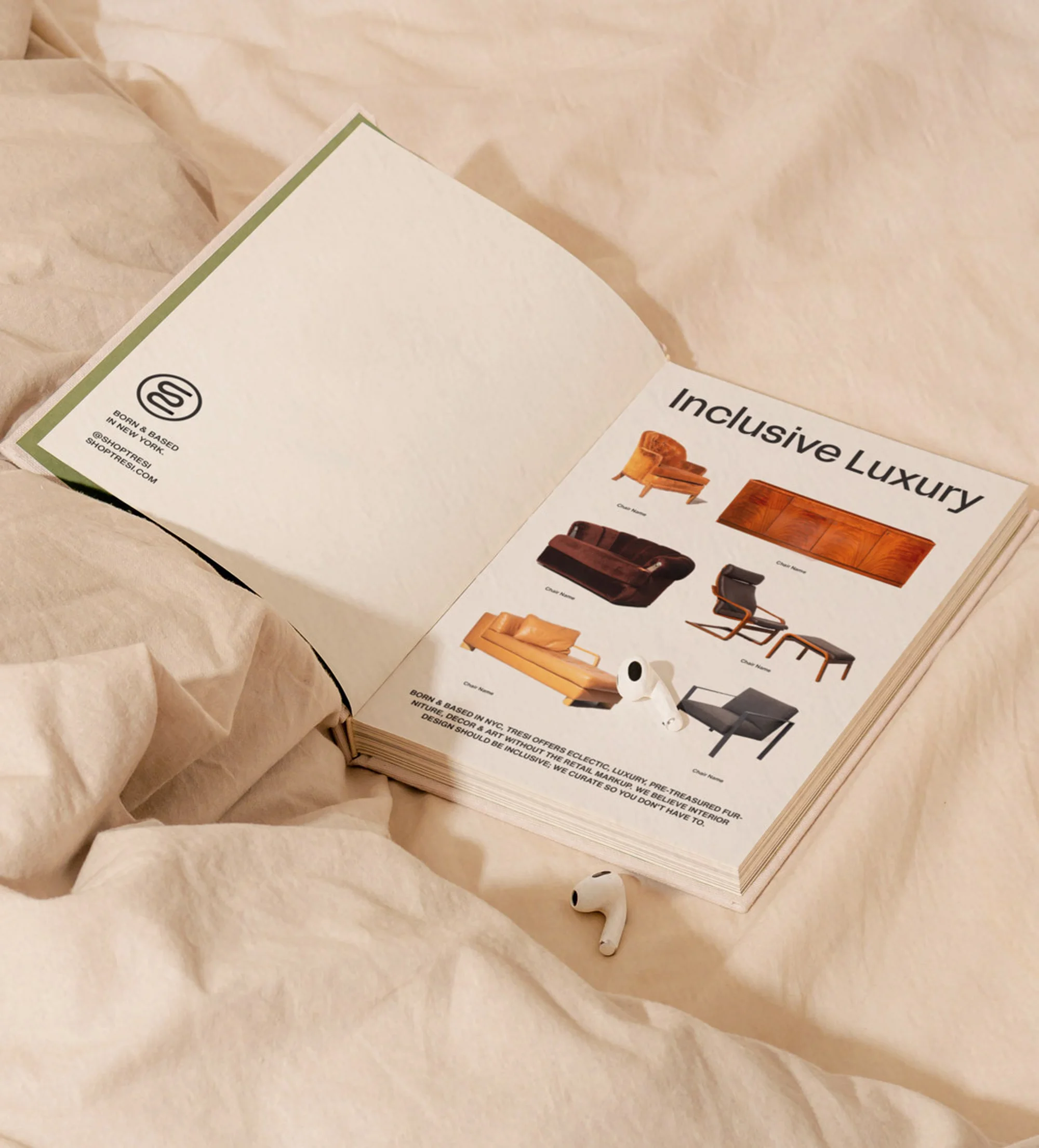 Open magazine displaying furniture on a bed with wireless earbuds nearby. The magazine showcases modern furniture designs.