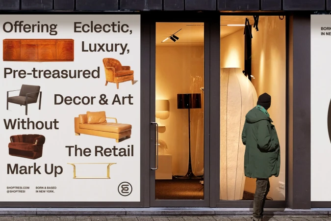 Storefront window with furniture display and passerby looking in. Window features text about pre-treasured decor and art inside the retail location.