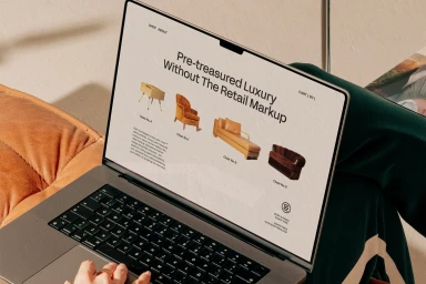 Close-up of a laptop displaying an e-commerce website interface for pre-treasured luxury furniture by Tresi