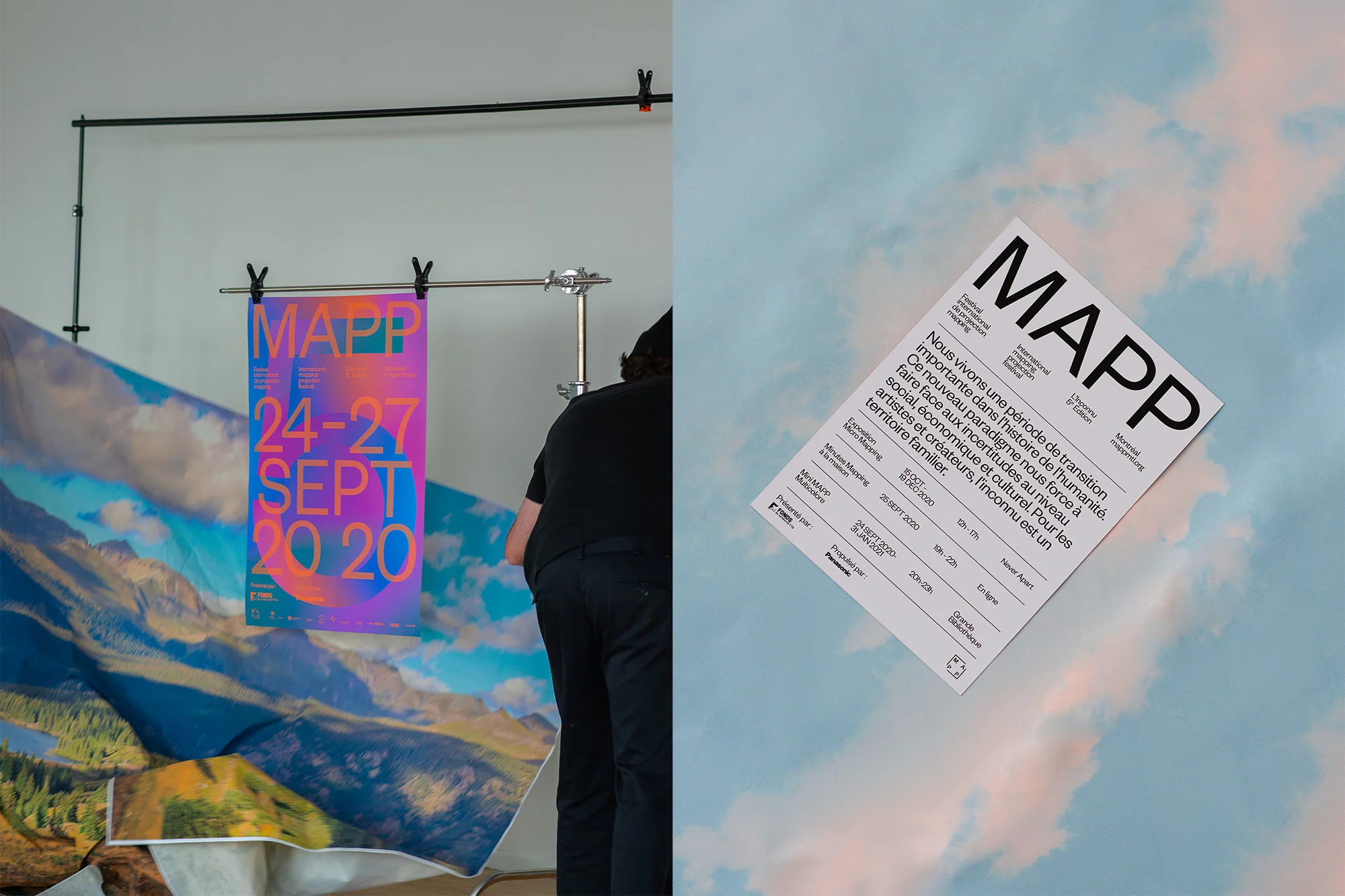 Promotional shot showcasing a vibrant poster advertising the MAPP festival, with a person partially visible arranging a backdrop.