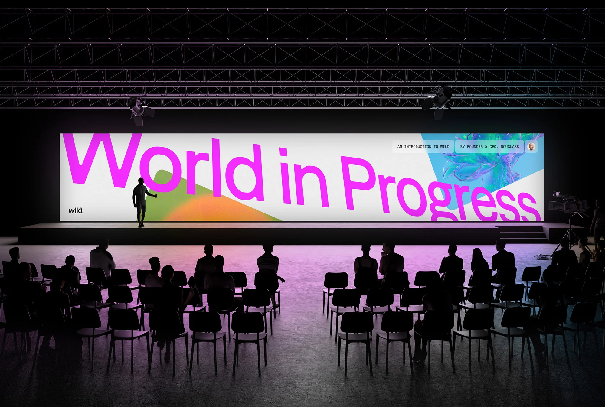 Audience listens to presenter standing on stage in front of a large screen that reads, 'World in Progress' during presentation.