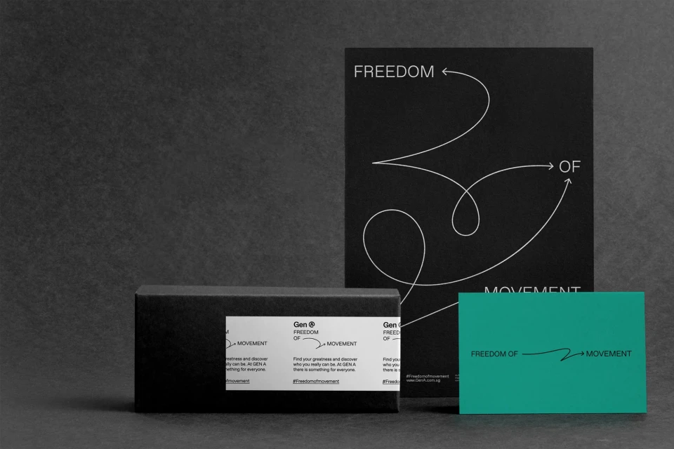 Promotional materials on a gray surface include black box with brand label next to black and turquoise cards with 'Freedom of Movement' text.