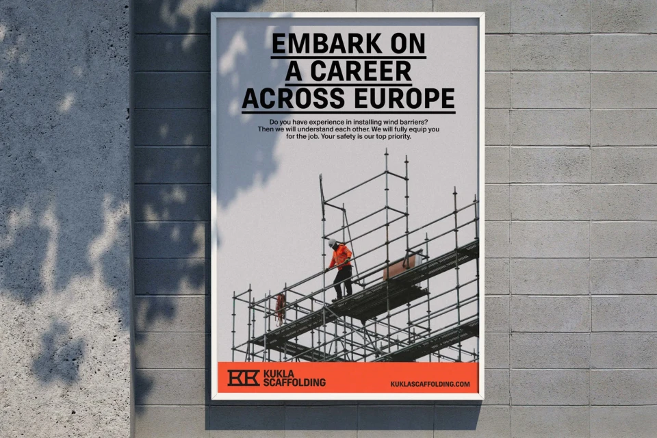Recruitment poster for Kukla Scaffolding showing construction workers on scaffolding against a grey sky, affixed to a textured concrete wall.