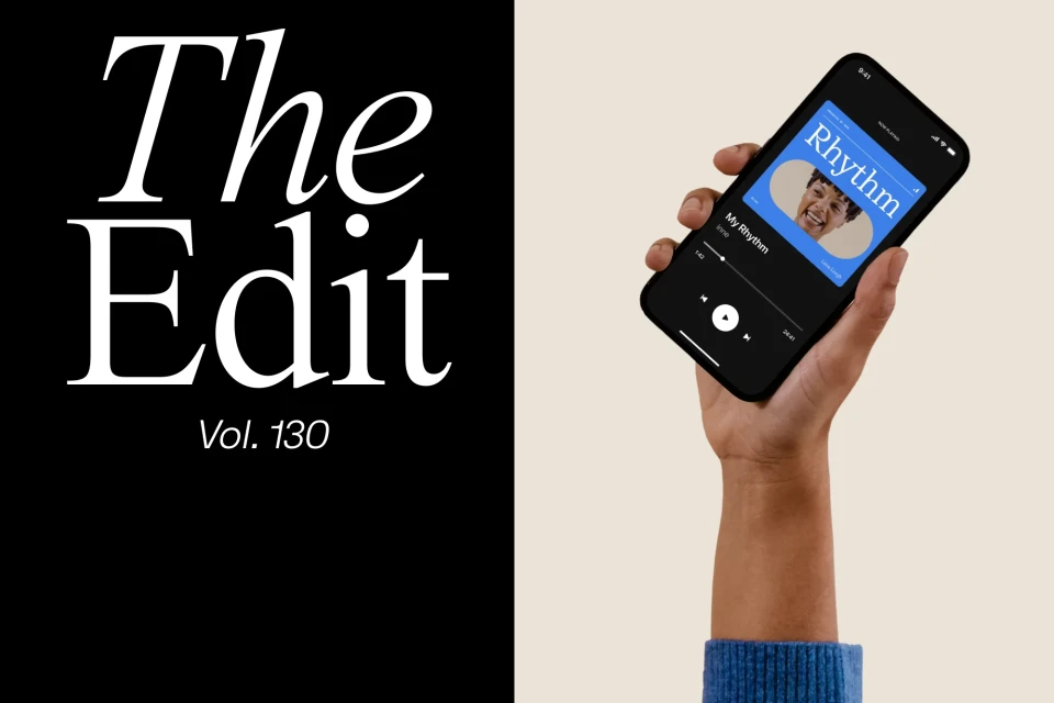 Hand holding a smartphone displaying the cover art of the 'Rhythm' playlist on a beige and black background with white text.