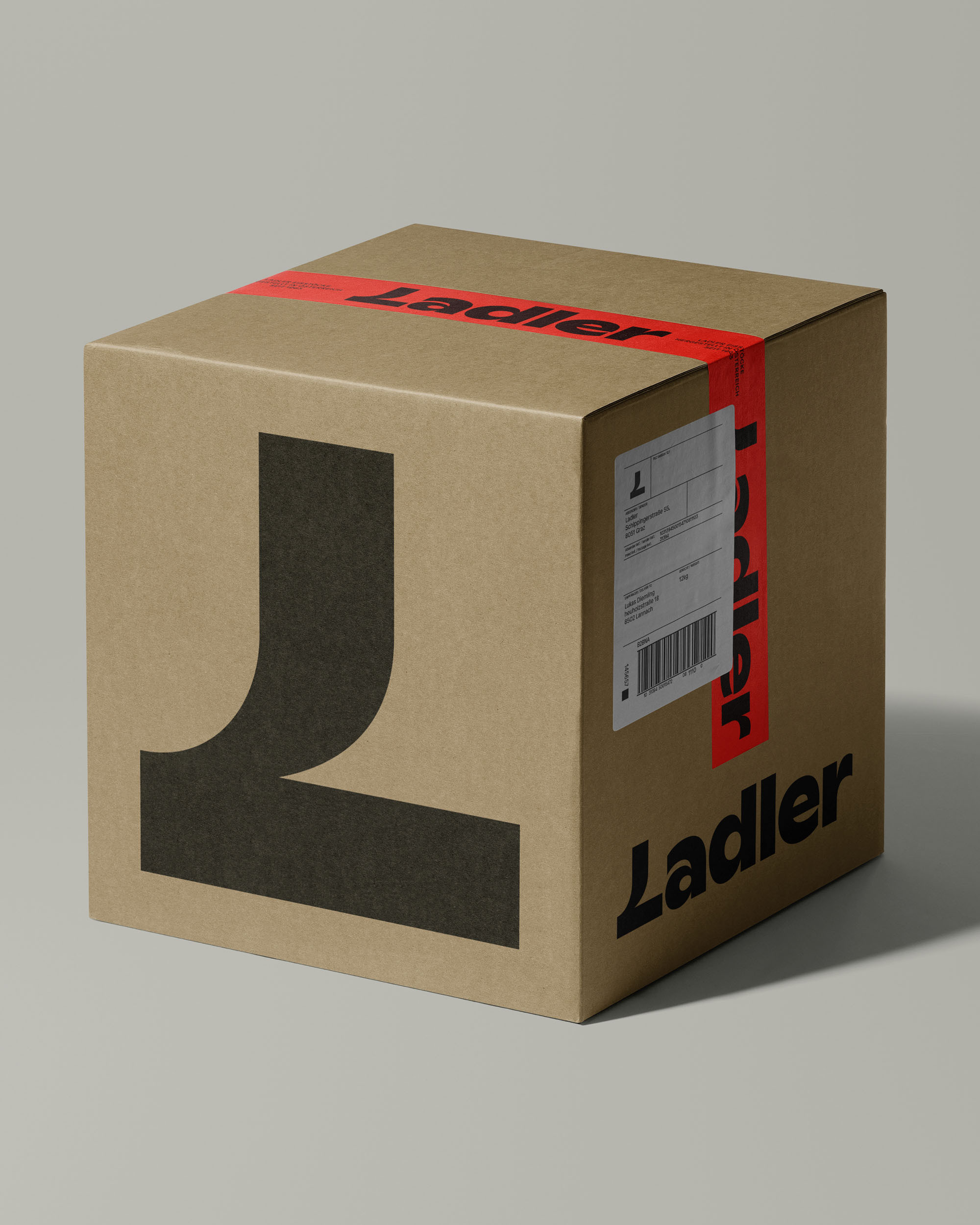 Brown cardboard shipping box with black 'L' logo and red tape with 'Ladler' printed on it against a neutral gray background.