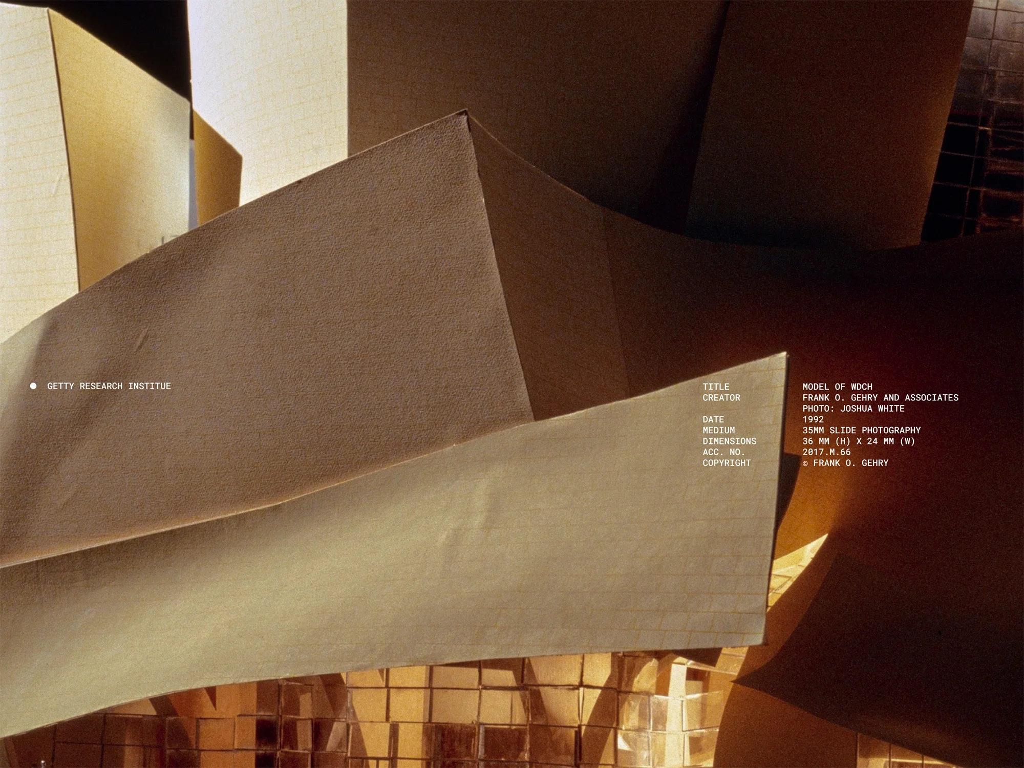 Architectural model of a building with light brown angular planes and geometric shapes, created by Frank Gehry and Associates in 1992.