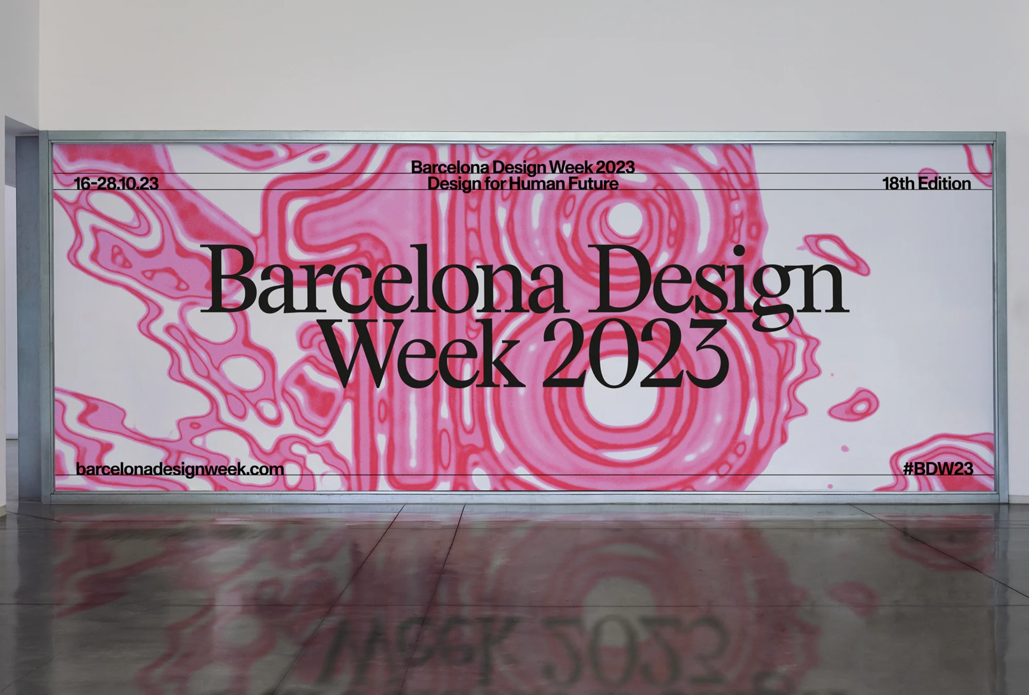 Promotional poster for Barcelona Design Week 2023, featuring a pink and white abstract design and event details, mounted indoors.