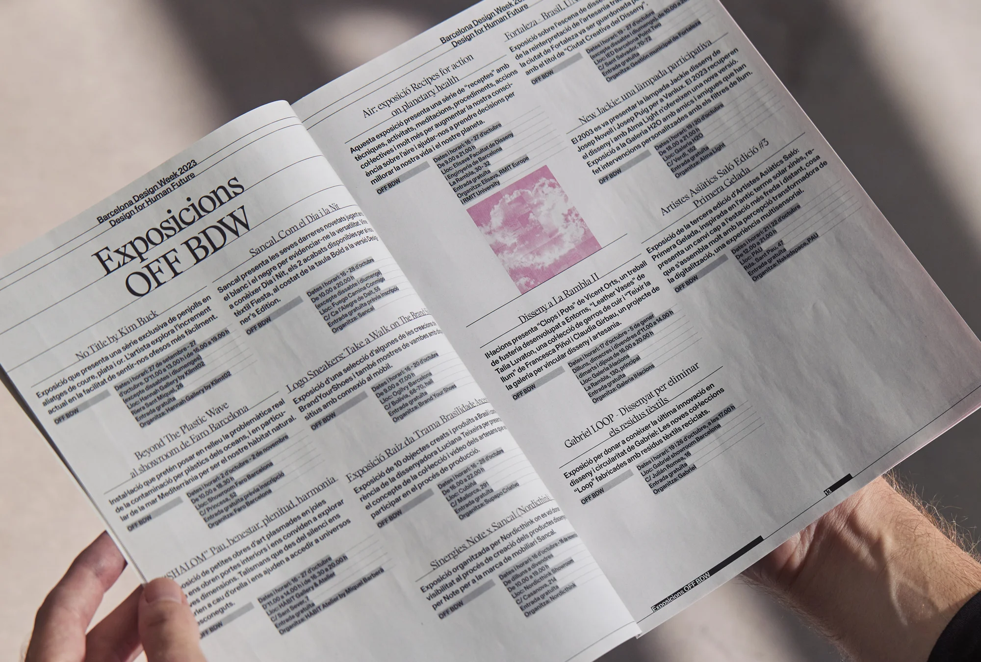 A person holds open a magazine featuring articles and advertisements from Barcelona Design Week 2023, with a focus on design for the future.