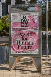 Outdoor advertising billboard displaying Barcelona Design Week branding on a paved public square