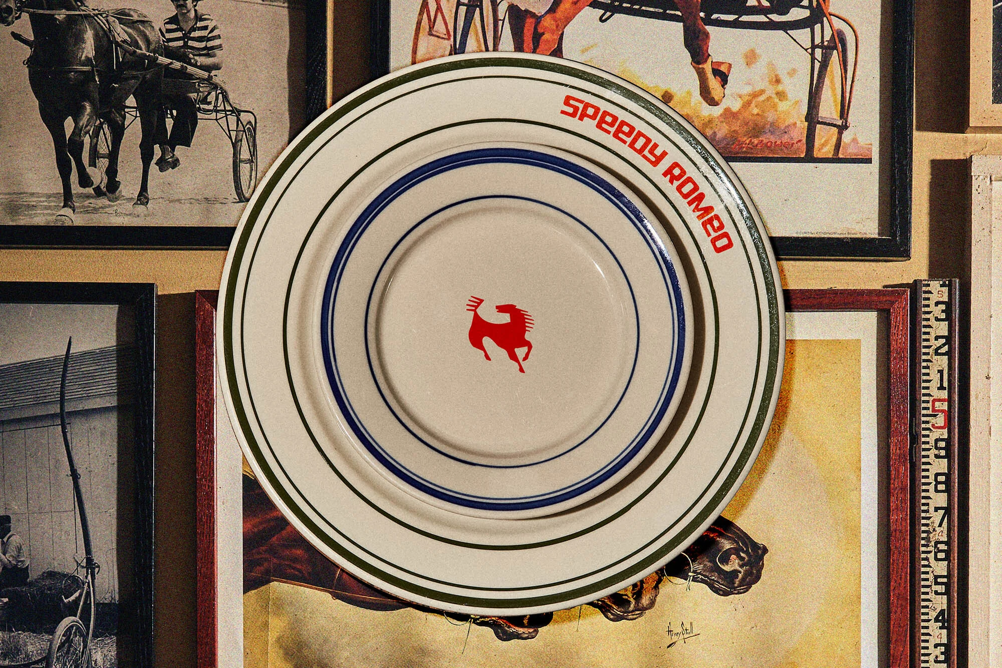 Decorative display of antique plates with horse racing imagery framed among vintage photographs and memorabilia in a warm, ambient setting.