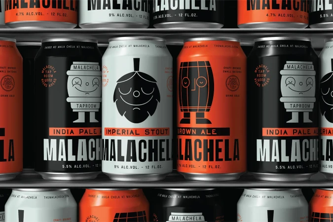 Assortment of Malachela brand craft beer cans in various colors, including black, white, and orange, displayed on a metal shelf.