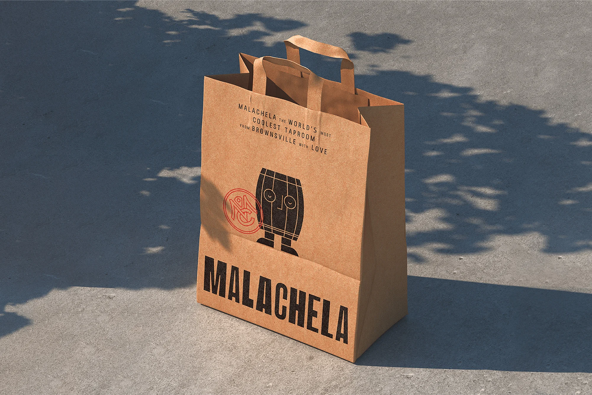 A brown paper bag with a black and red logo and the word 'MALACHELA' printed on it, sits on a gray concrete surface with tree shadows.