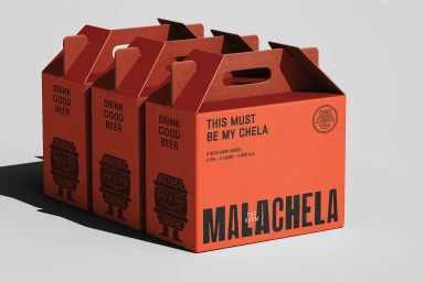 Three red cardboard beer carrier boxes with black typography and carrying handles on a white background