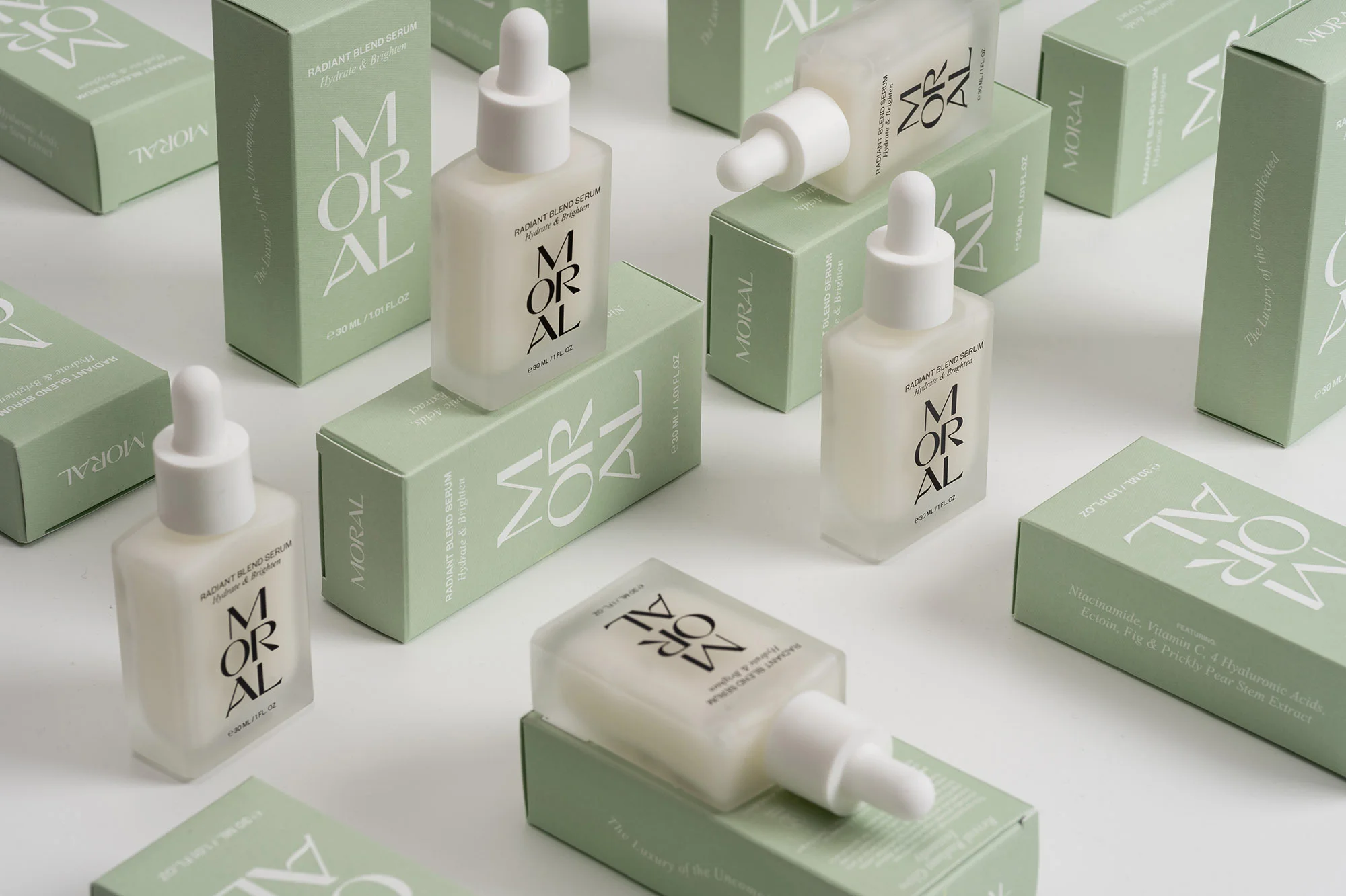 Cosmetic serum bottles and packaging with the MORAL brand displayed. Minimalist beauty product shot for skincare and beauty advertising.