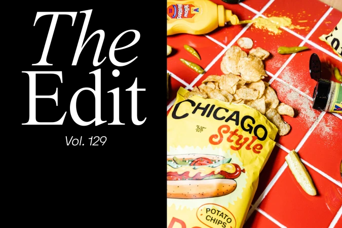 Close-up of a bag of Chicago Style potato chips with assorted condiments and garnishes on a red and white tiled surface.
