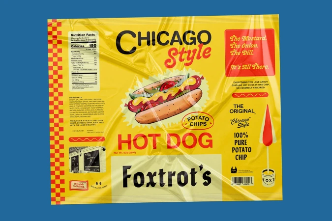 Chicago style hot dog potato chips bag against a blue background. The bag is yellow with red lettering, plus a cartoon hot dog.