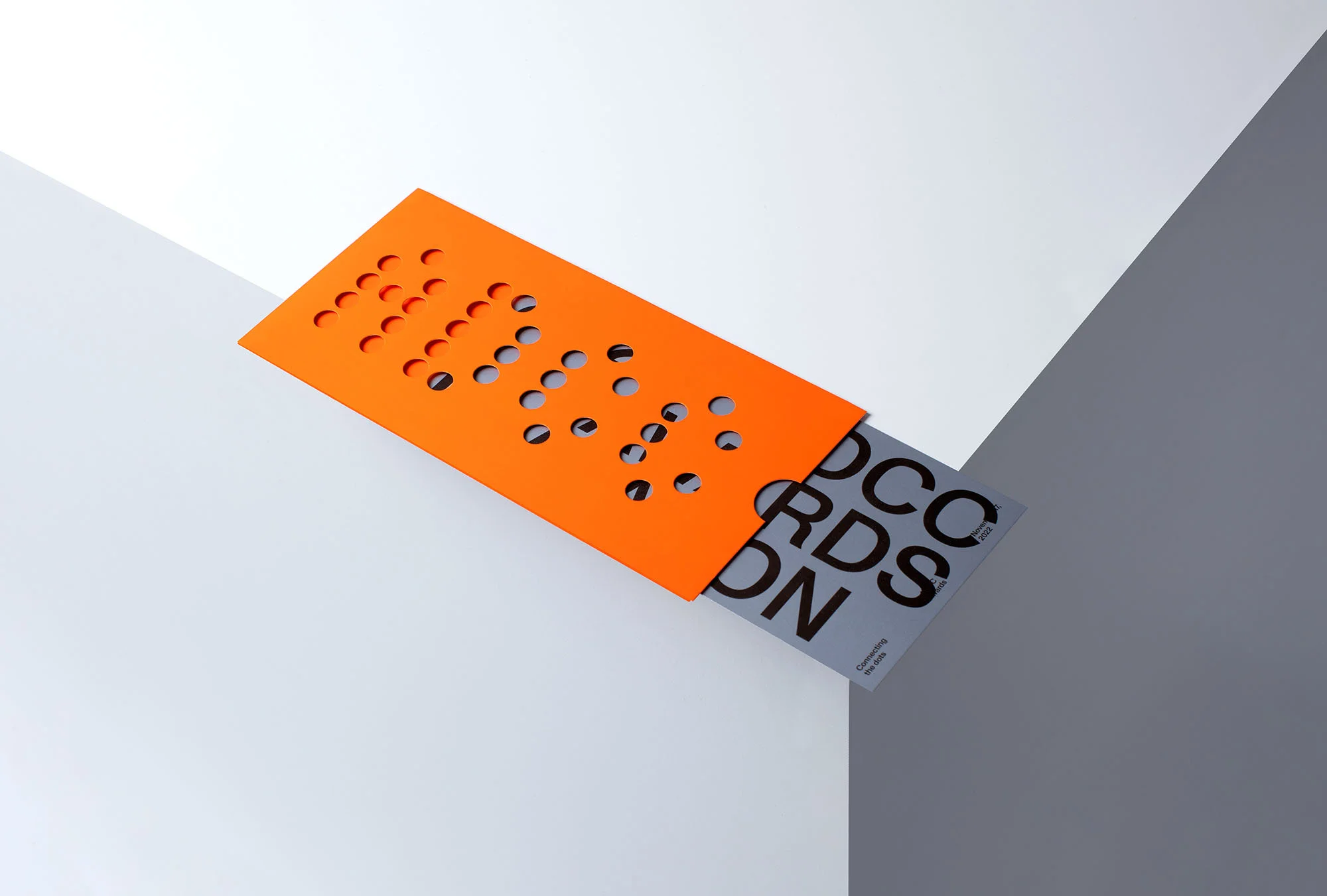 Graphic design featuring an orange perforated card partially inserted into a gray card with text on a white and gray angular background.