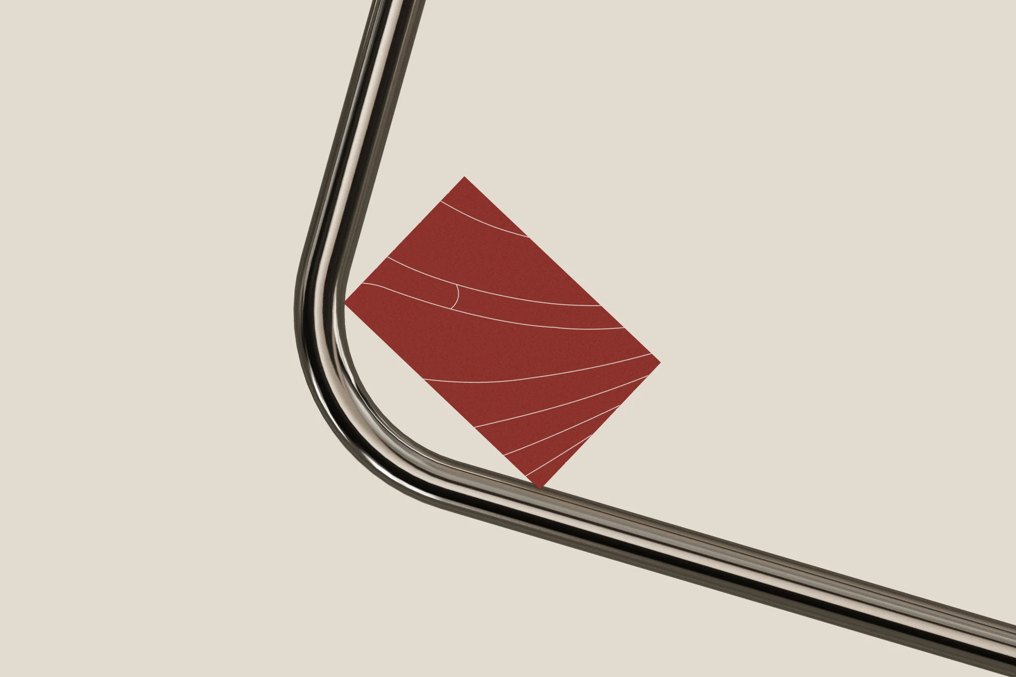 Abstract composition featuring a chrome metal pipe intersecting with a dark red, square graphic element on a cream-colored background.