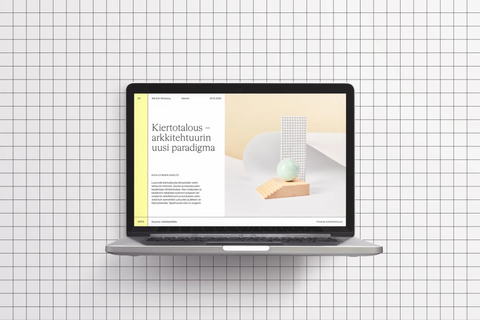 Laptop displaying a sleek website design featuring modern typography and geometric shapes, set against a clean, minimalist background.