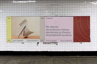 A large multi-panel advertising billboard mounted on a white tiled wall displaying typography and architectural imagery