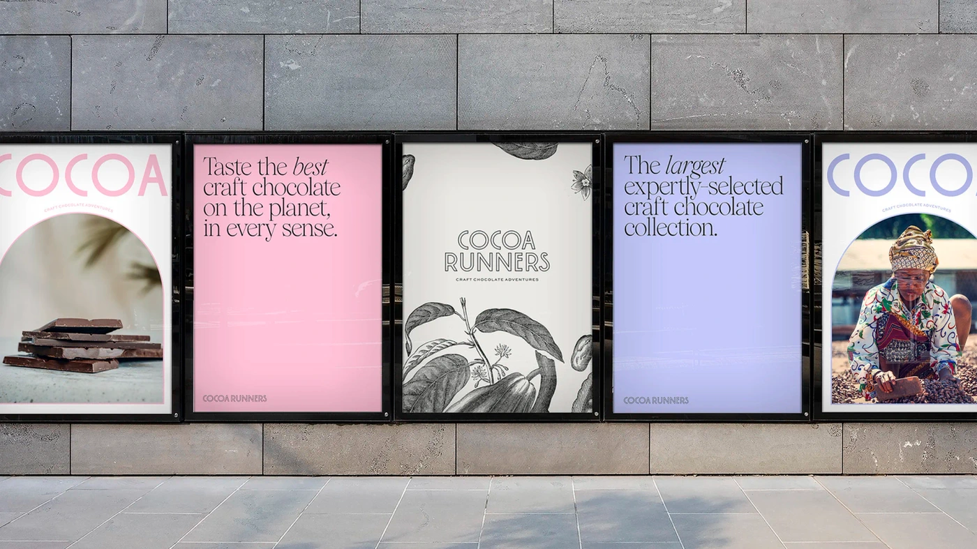 Five framed advertising posters mounted on a grey stone wall displaying typography and botanical illustrations for Cocoa Runners.