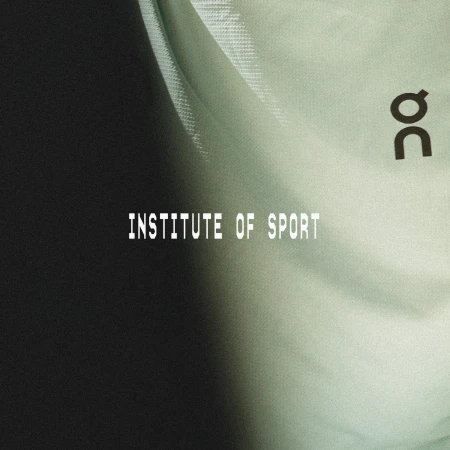 A studio shot of a draped, light-green textured fabric with black text spelling 'Institute of Sport' and an athletic brand logo.
